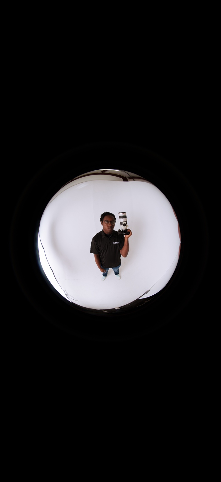 Portrait of Tristian Perkins holding a camera