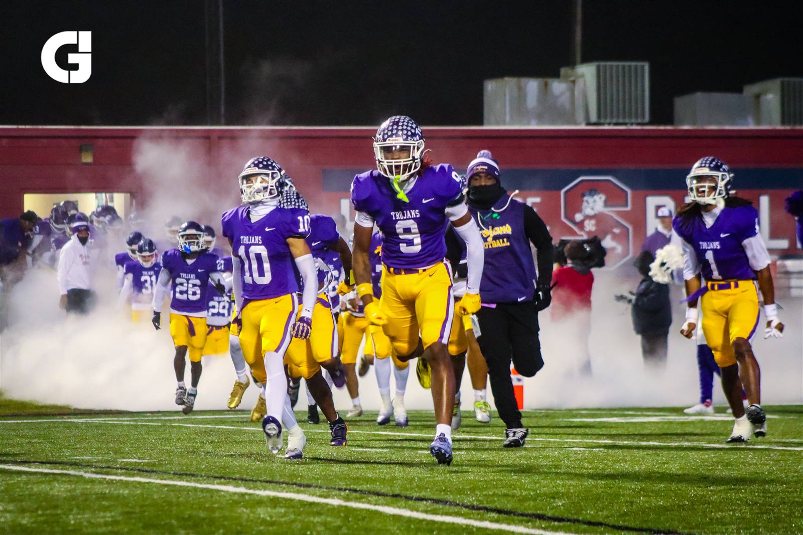 Football team entering the field through smoke